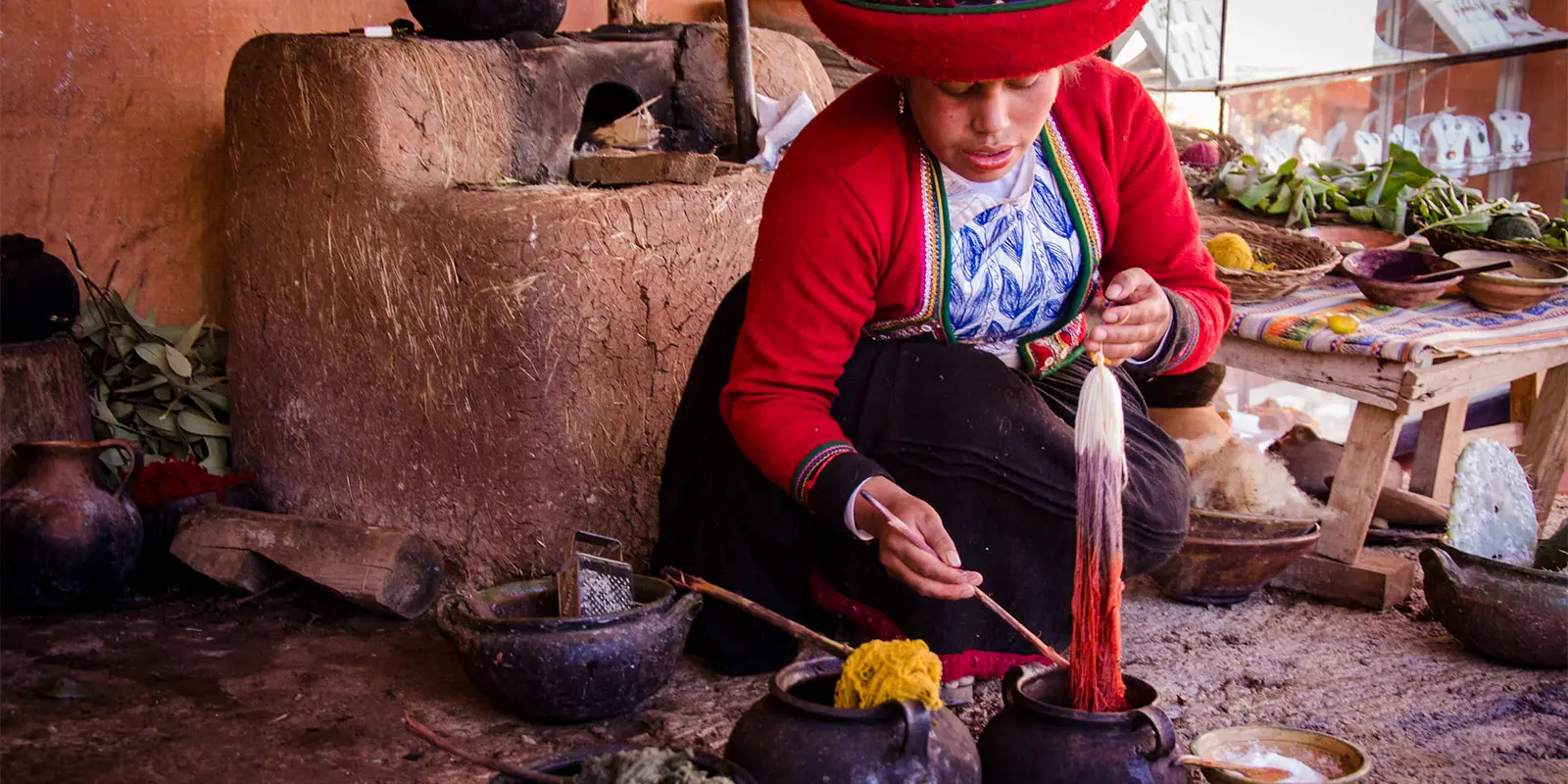 Woman dyeing yarn in traditional attire cusco